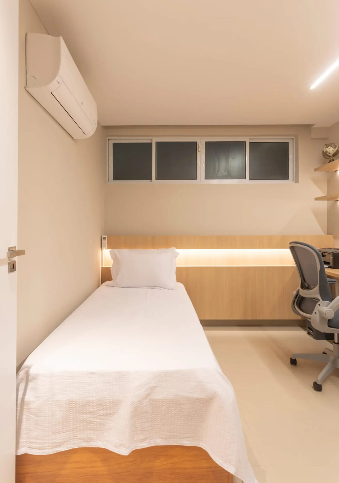 Segundo quarto com cama de solteiro e espaço de home office