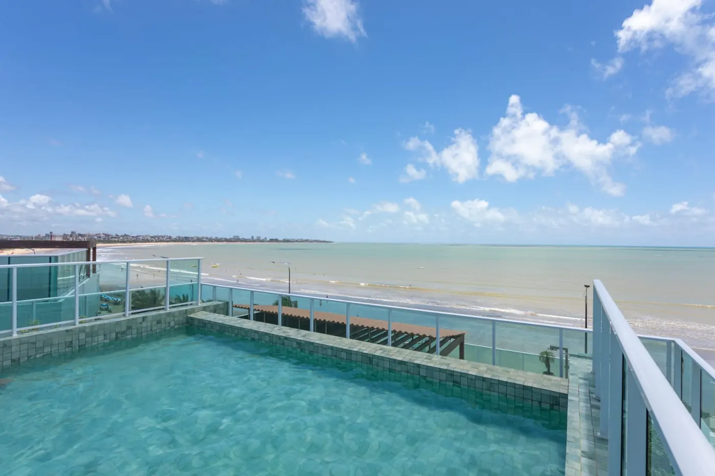 Piscina do condomínio com vista aberta para o mar do Bessa
